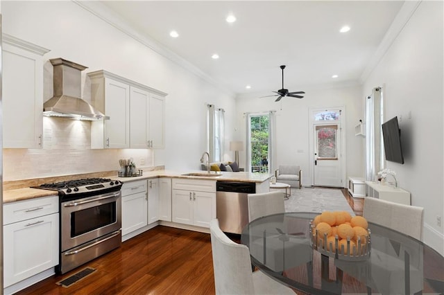 8428 Willow St, New Orleans, LA 70118 - kitchen featuring appliances with stainless steel finishes, wall chimney range hood, dark wood finished floors, recessed lighting, and ceiling fan