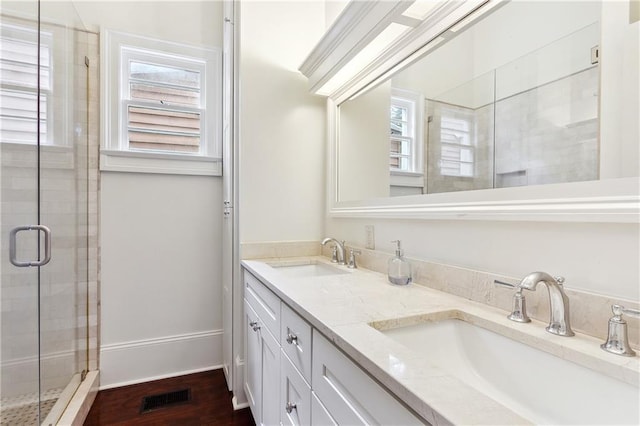 full bath featuring double vanity, visible vents, a shower stall, and a sink