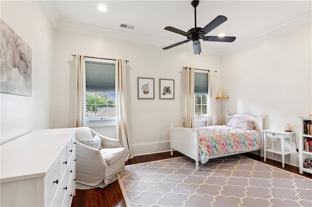 bedroom with visible vents, ornamental molding, baseboards, and wood finished floors