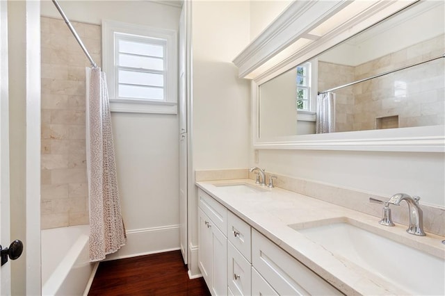 bathroom with double vanity, shower / bathtub combination with curtain, wood finished floors, and a sink