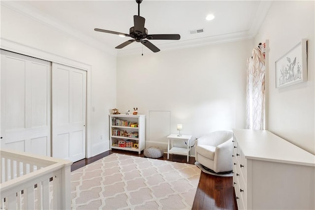 bedroom featuring visible vents, wood finished floors, a closet, crown molding, and ceiling fan