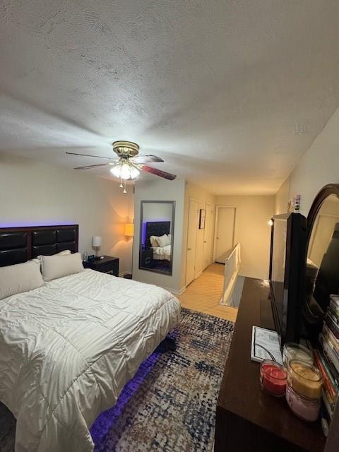 bedroom featuring a textured ceiling, wood finished floors, and a ceiling fan