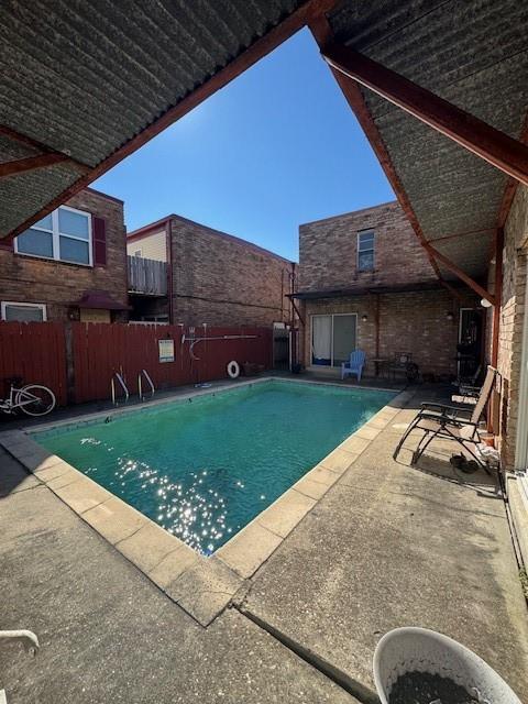 pool with a patio and fence