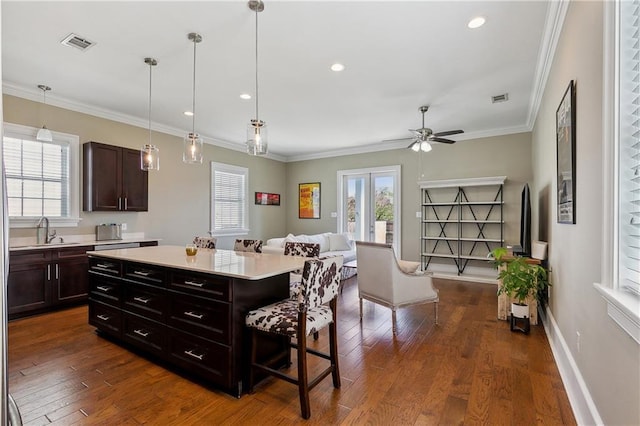 kitchen featuring visible vents, ornamental molding, and light countertops