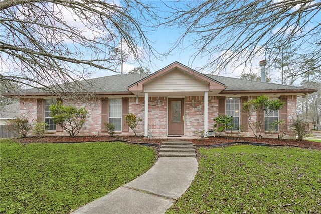 single story home featuring a front lawn and brick siding