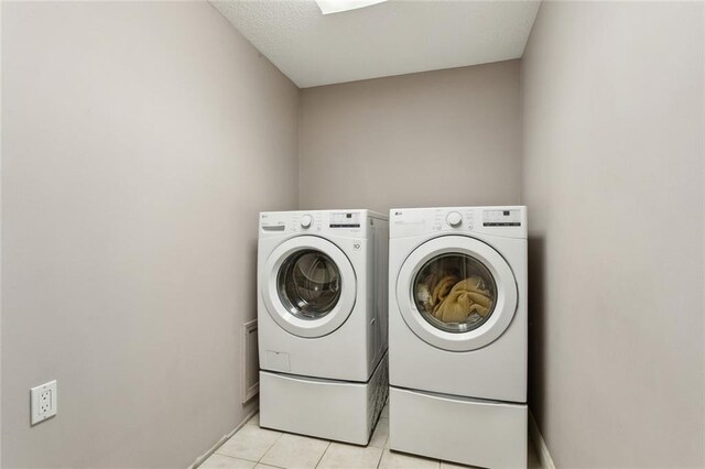 laundry room with independent washer and dryer, laundry area, and light tile patterned floors