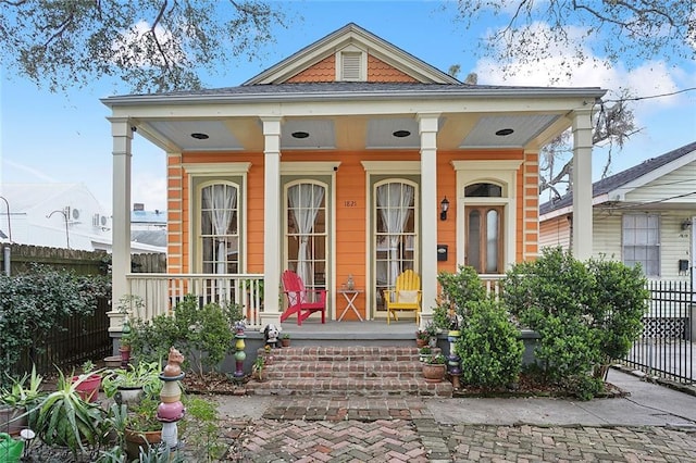 view of front of home with covered porch and fence