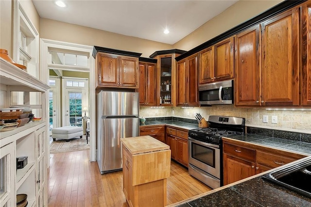 kitchen featuring tasteful backsplash, appliances with stainless steel finishes, and light wood-style floors