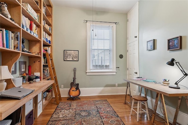 office area with baseboards and wood finished floors