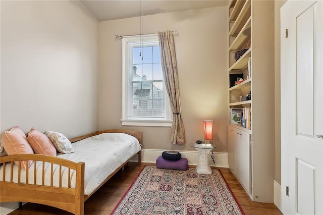 bedroom featuring baseboards and wood finished floors