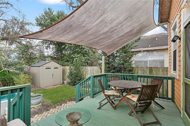 wooden deck with a storage unit, outdoor dining area, an outdoor structure, and fence