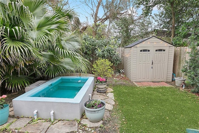 view of pool with a yard, a fenced backyard, an outbuilding, an in ground hot tub, and a storage unit