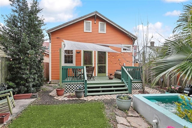 back of house with a deck and fence