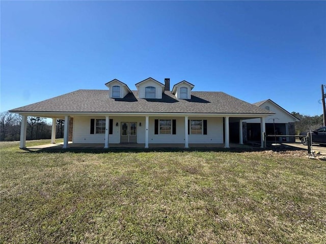 view of front of house with a front yard and a shingled roof