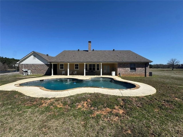 outdoor pool featuring a patio and a lawn