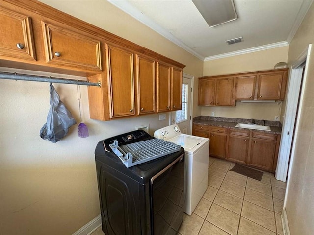 clothes washing area with visible vents, crown molding, washing machine and dryer, cabinet space, and a sink