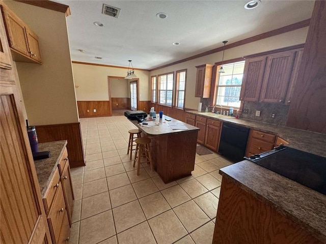 kitchen with visible vents, a sink, wood walls, wainscoting, and dishwasher