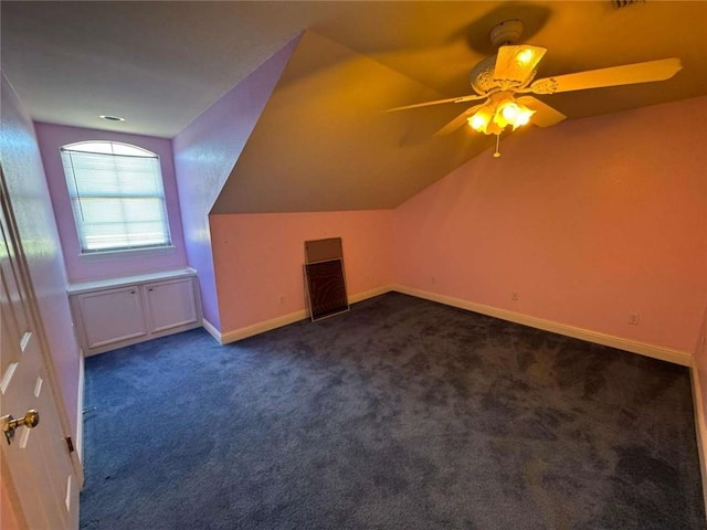 additional living space with baseboards, lofted ceiling, ceiling fan, and dark carpet