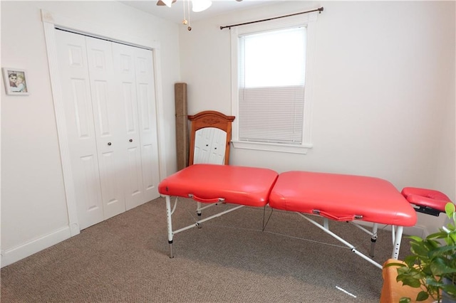 recreation room with carpet flooring, a ceiling fan, and baseboards