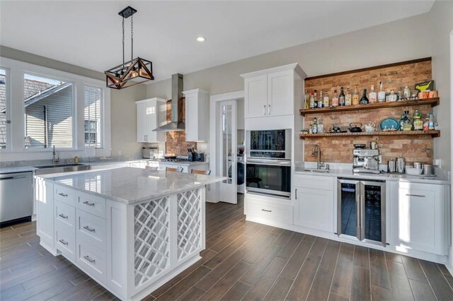 926 City Park Ave, New Orleans, LA 70119 - kitchen featuring tasteful backsplash, dark wood-type flooring, beverage cooler, stainless steel appliances, and wall chimney exhaust hood