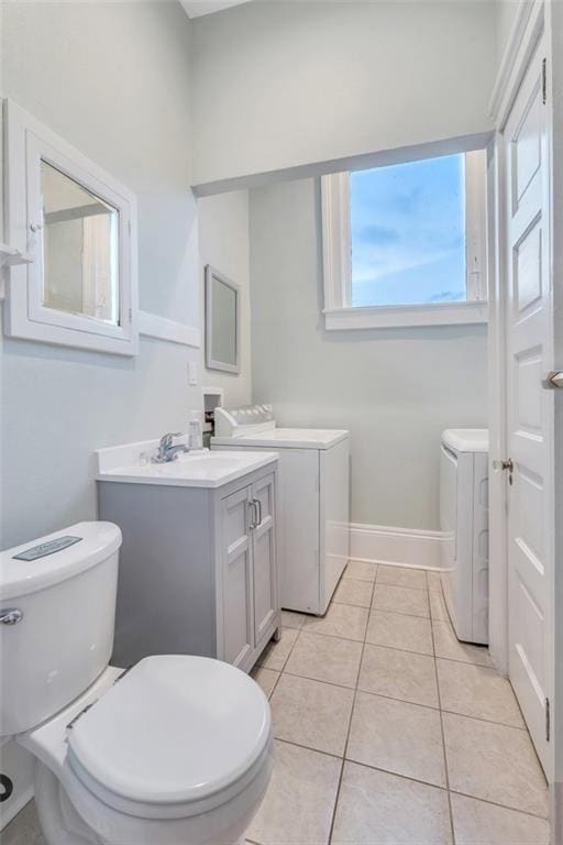 926 City Park Ave, New Orleans, LA 70119 - bathroom with toilet, tile patterned flooring, baseboards, vanity, and washing machine and clothes dryer