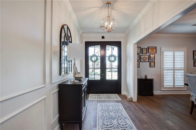 foyer with baseboards, a chandelier, ornamental molding, french doors, and wood finished floors