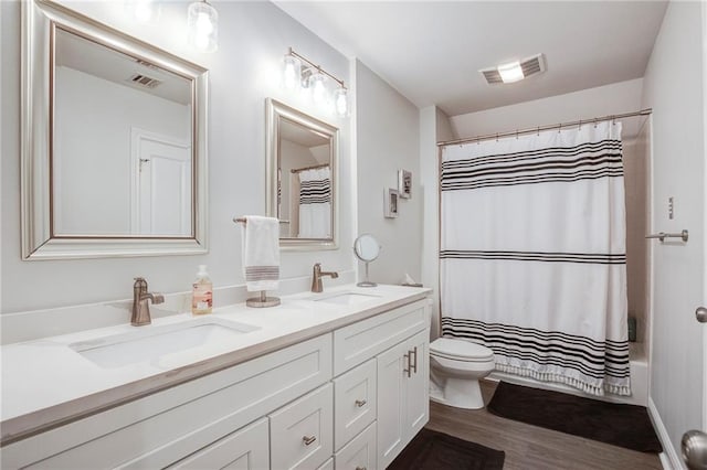 bathroom with toilet, visible vents, and a sink