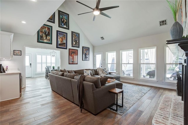 living room featuring visible vents, high vaulted ceiling, a ceiling fan, and wood finished floors