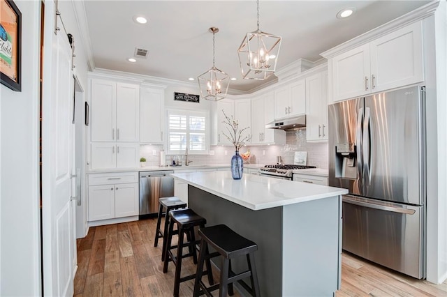 kitchen featuring under cabinet range hood, appliances with stainless steel finishes, and white cabinets