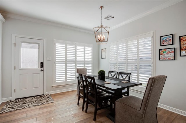 dining area featuring baseboards, visible vents, light wood-style flooring, ornamental molding, and a notable chandelier