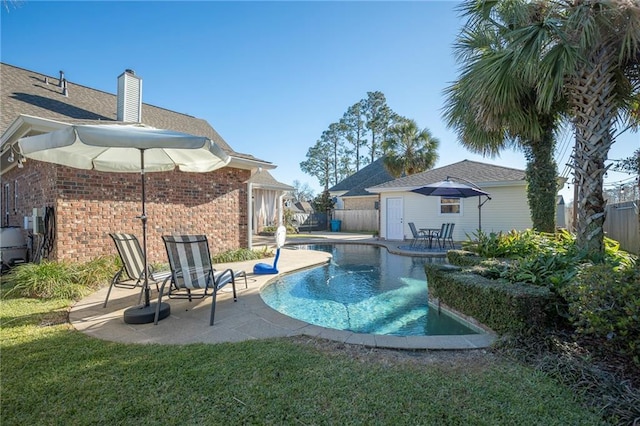 view of swimming pool with a fenced in pool, a patio area, a yard, a fenced backyard, and an outbuilding