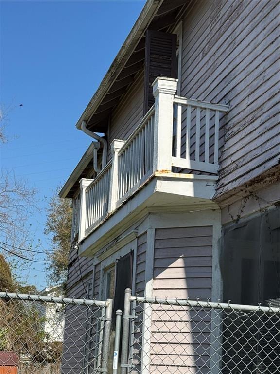 view of property exterior with a balcony and fence