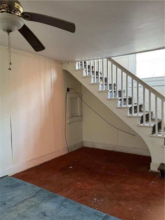 stairs with baseboards and ceiling fan