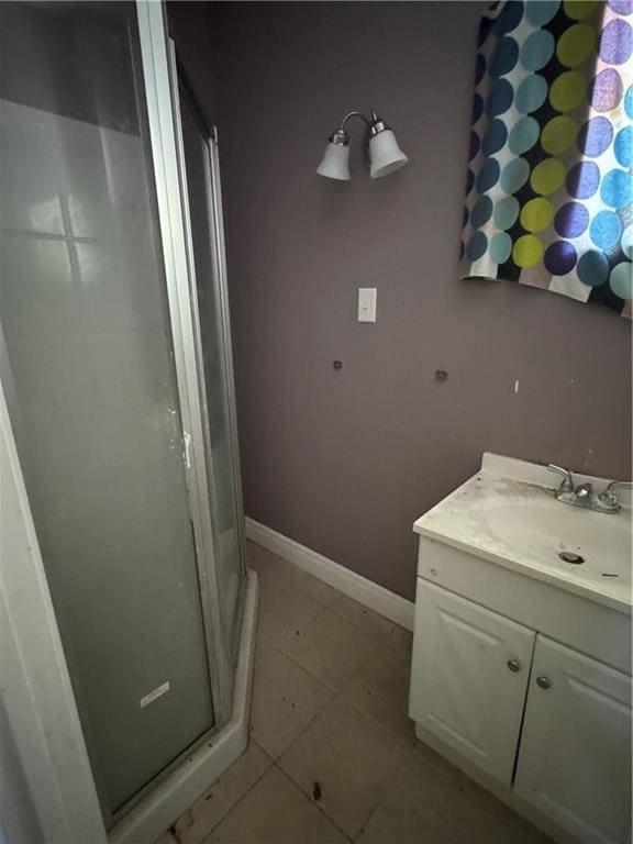 bathroom featuring tile patterned floors, a shower stall, vanity, and baseboards