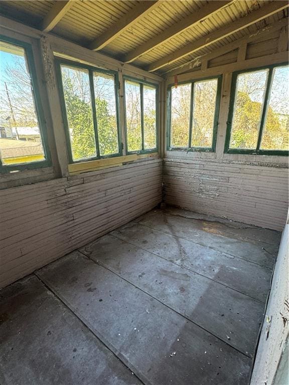 unfurnished sunroom with lofted ceiling with beams