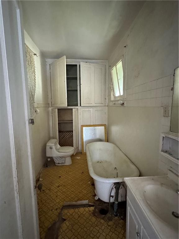 full bath with a soaking tub and vanity