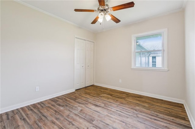 unfurnished bedroom featuring wood finished floors, baseboards, and ornamental molding