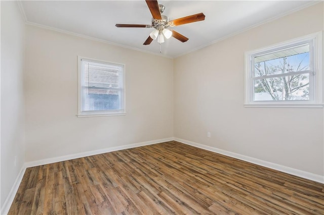 empty room featuring baseboards, wood finished floors, and ornamental molding