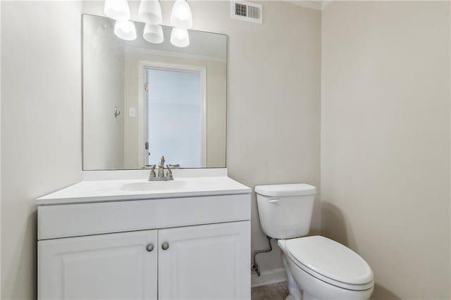 half bath featuring visible vents, toilet, and vanity