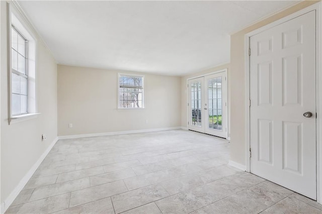 unfurnished room featuring french doors and baseboards