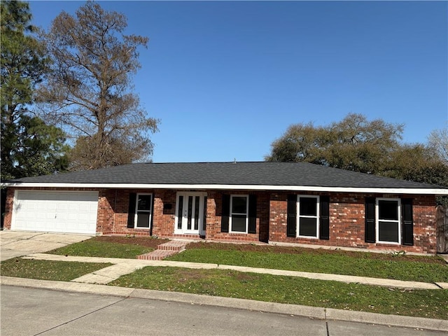 single story home with concrete driveway, a front lawn, french doors, a garage, and brick siding