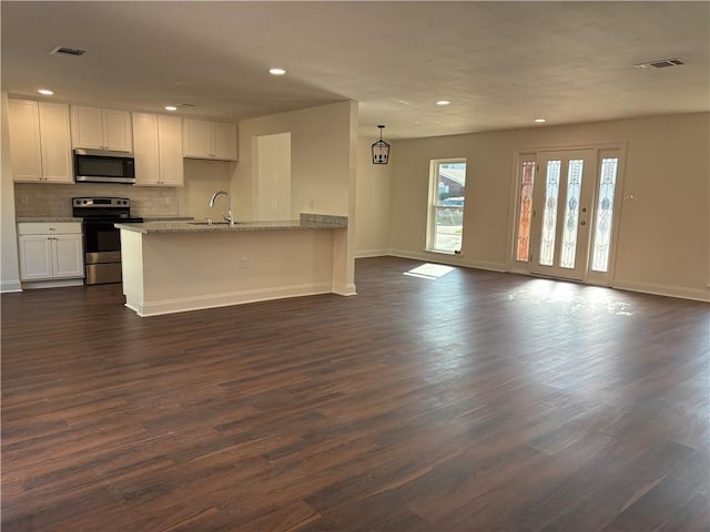 kitchen with open floor plan, visible vents, white cabinets, and stainless steel appliances