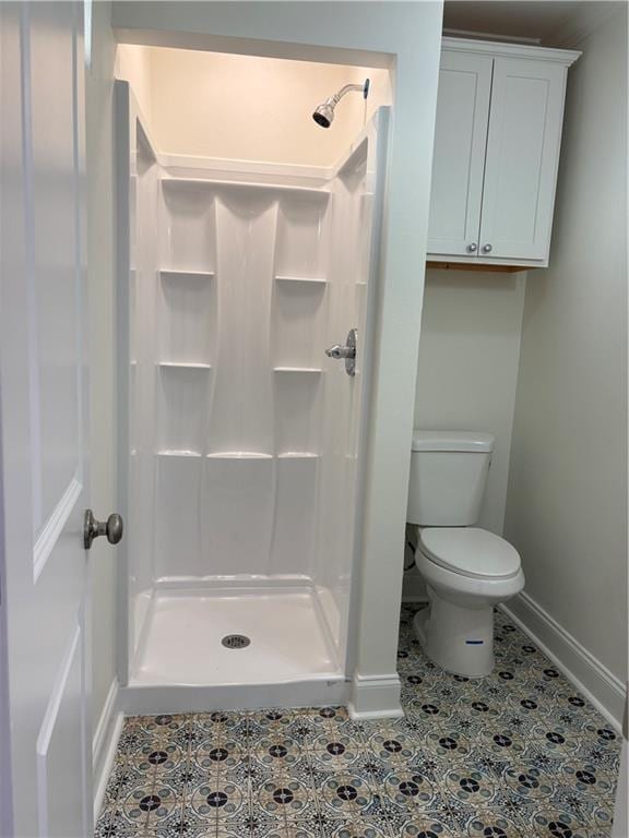 bathroom with tile patterned floors, a shower stall, toilet, and baseboards