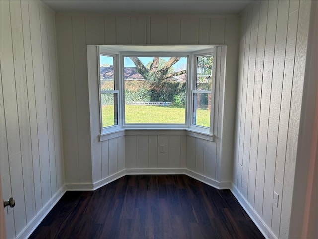 spare room featuring dark wood-style floors and baseboards