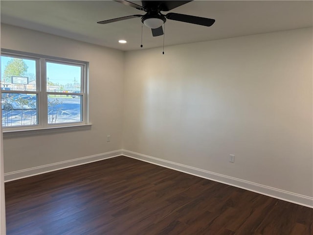 spare room featuring dark wood finished floors, recessed lighting, baseboards, and a ceiling fan