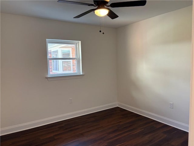 spare room featuring dark wood-style floors, ceiling fan, and baseboards