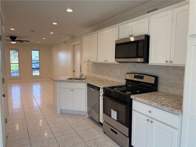 kitchen with marble finish floor, a sink, appliances with stainless steel finishes, a peninsula, and white cabinets