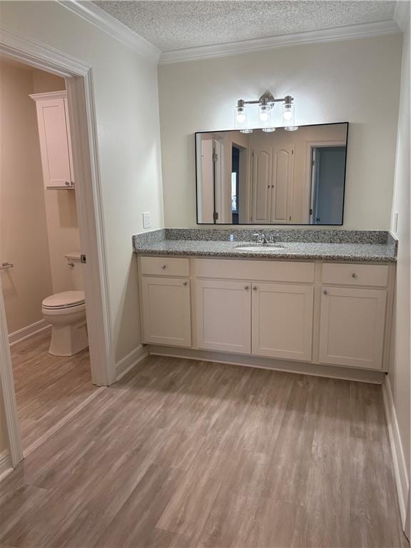 bathroom featuring wood finished floors, a textured ceiling, and ornamental molding