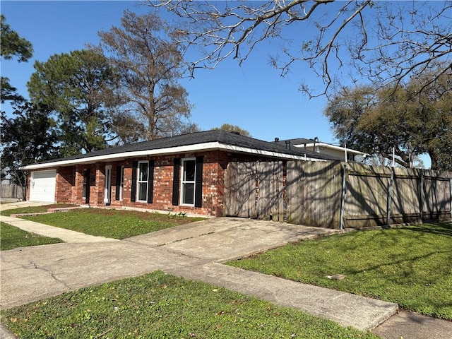 view of front of home with fence, concrete driveway, a front yard, an attached garage, and brick siding