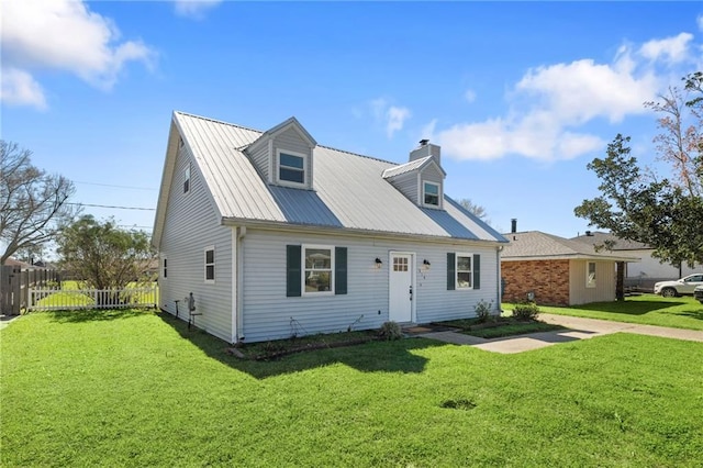 new england style home with metal roof, a front lawn, and fence